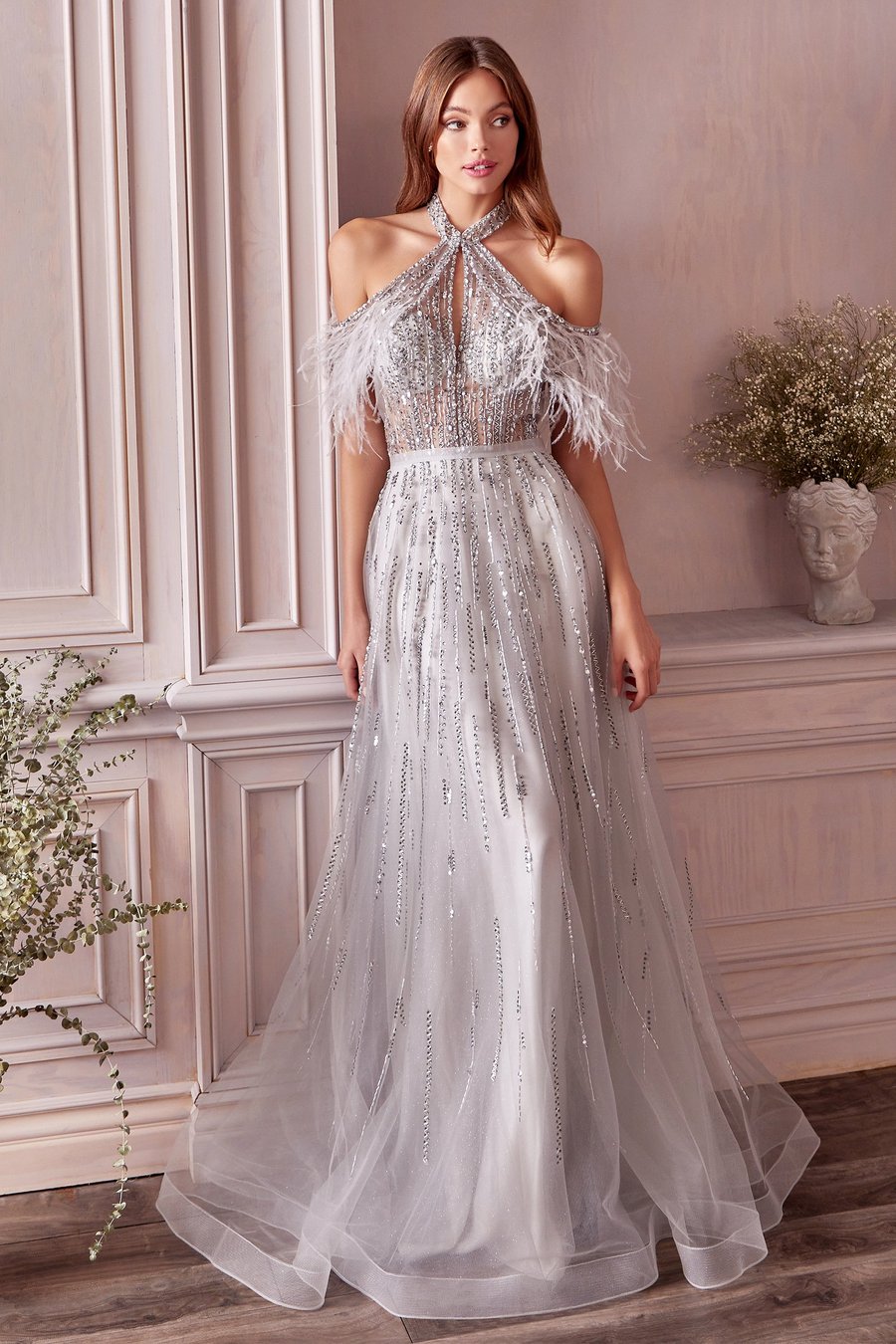 Andrea and Leo A1023 Feathered long halter off shoulder dress with A-line tulle skirt.  Swathed in crystals and silver beads, the Anastasia Gown is a luminous beaded ball gown that you'll never forget. From the halter neck, off shoulder tulle shawl with feathers softly drapes around the shoulder. The elongating beads fall linearly from the bodice to the soft A-line skirt that softly sways as you dance the night away.